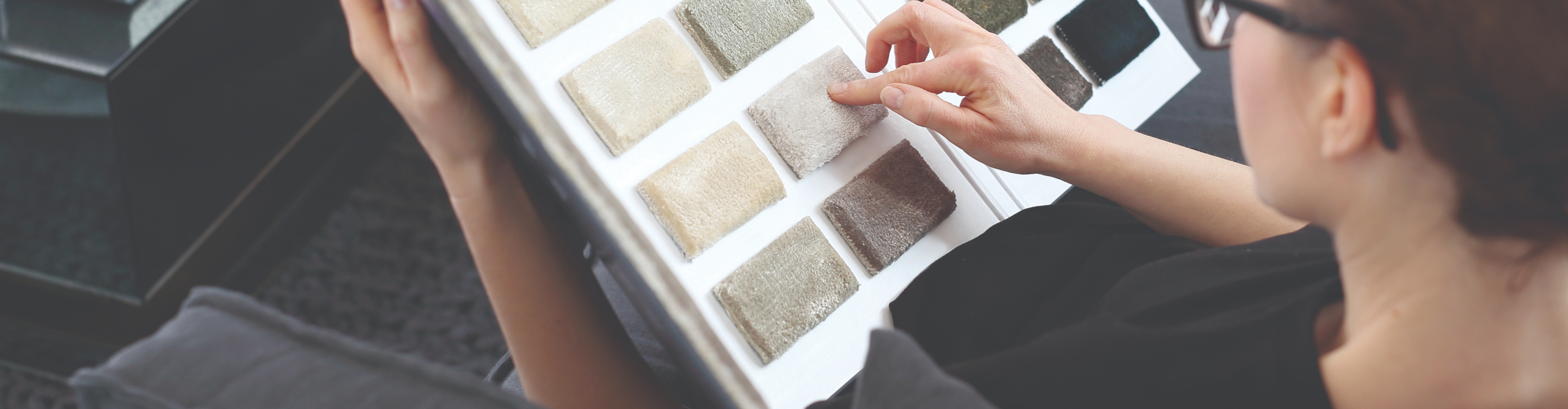 Carpet samples in a book with hands. 